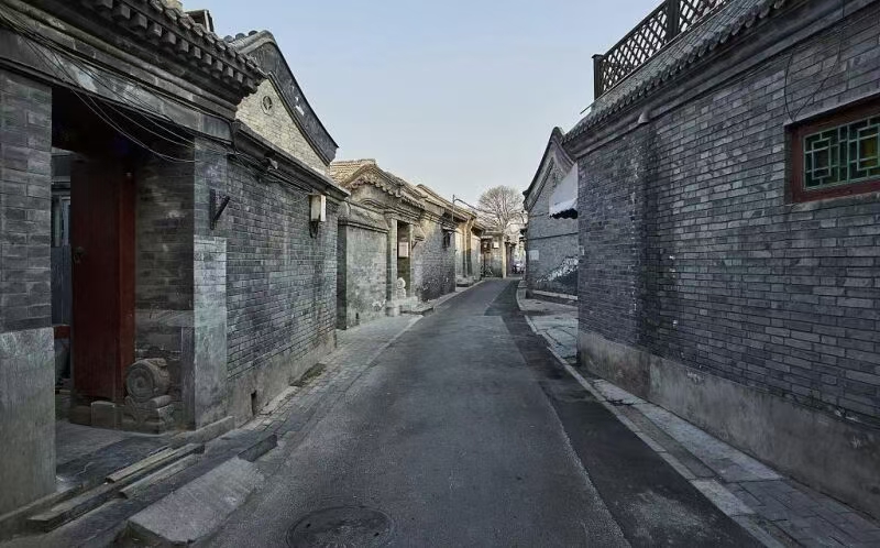 Traditional Beijing hutong alley with local restaurants and pedestrians
